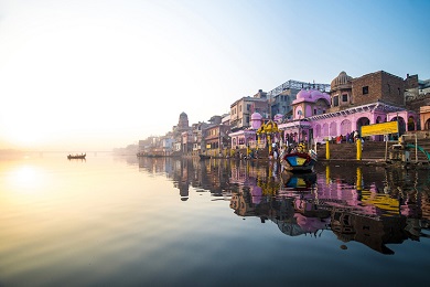 The sun rising over a river lined with buildings