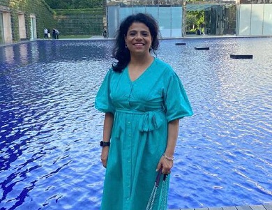 Woman standing with body of water behind her.