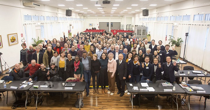 A large group of people posing for a commemorative photo in a conference room.