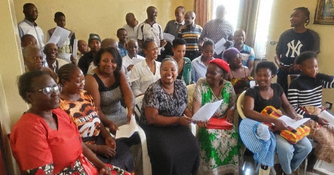 People seated indoors posing for a group photo.