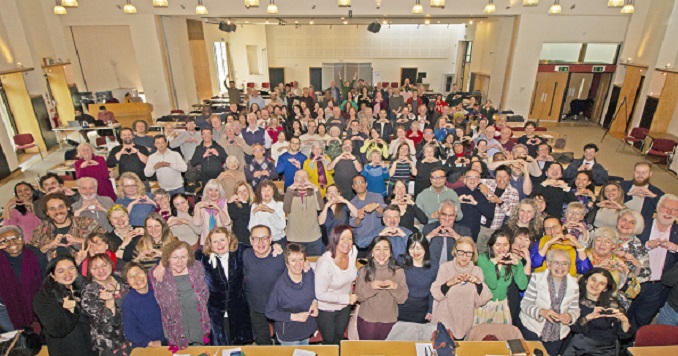 Un gran grupo de personas en una sala de conferencias posando para una foto conmemorativa.