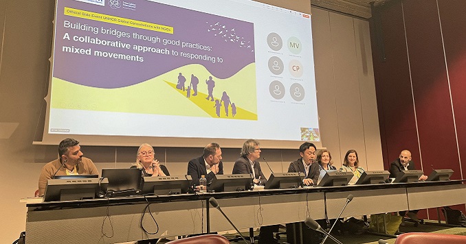 A panel of speakers seated at a long table.