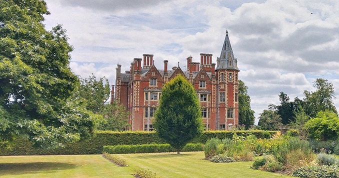 A mid-nineteenth-century stately home surrounded by trees.