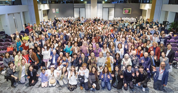 Un grupo de personas se hace una foto conmemorativa en una gran sala.