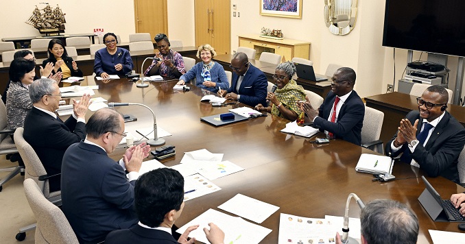 A group of people sitting around a table, engaged in discussion.