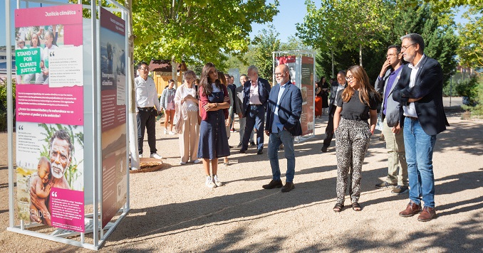 People viewing exhibition panels outdoors.