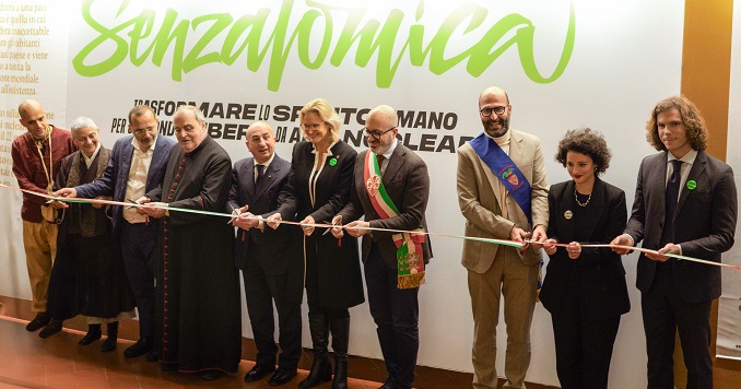 Un grupo de personas en fila detrás de la cinta de inauguración, preparados para la ceremonia del corte.