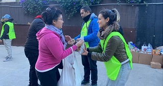 A woman handing a food donation to another woman.