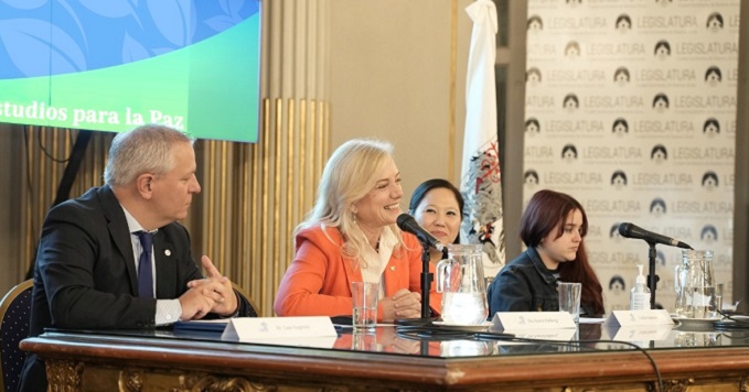 Four panelists at a conference sitting at a table with microphones.