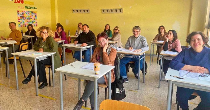 Adults sitting at desks in a classroom.