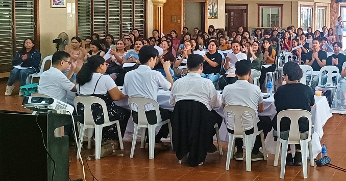 People sitting in a large room listening to a lecture.