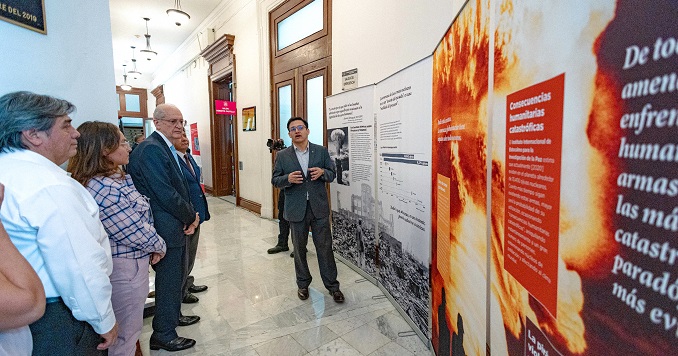 Personas contemplando paneles de una exposición.