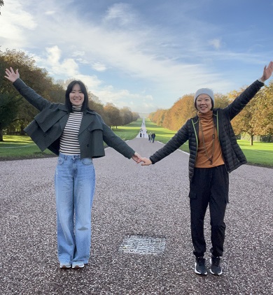 Two friends hold hands at the start of a large path.