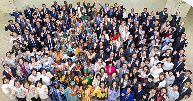 A large group of people looking up at the camera lens and posing for a commemorative photo.