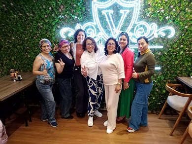 A group of women pose together for a commemorative photograph in a restaurant.