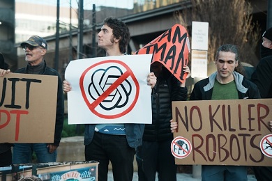 Three protesters holding signs against AI and killer robots.
