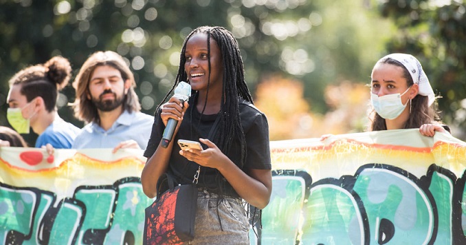 Vanessa Nakate holding a microphone speaking at a demonstration