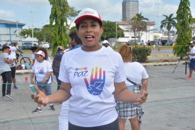 Una foto al aire libre de una mujer con participantes del evento al fondo