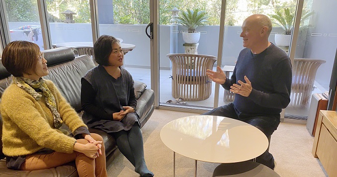 A man and two women talking at a table