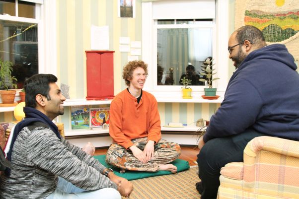 Three men in conversation in a small living room